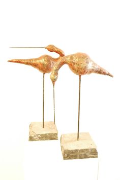 two metal birds standing on top of each other