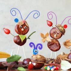 some very cute little bugs on sticks by some leaves and plants with eyes painted on them