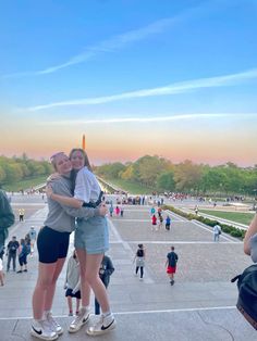 two women hugging each other in front of the lincoln memorial