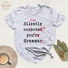 I'm Silently Correcting Your Grammar Shirt, Funny Grammar Tshirt, Sarcasm Gift Outfit, English Teacher Funny Tee, English Teacher Gift Tee. Welcome to BestMomentTees! Step into a world of comfort and style with our handmade shirts from the renowned Bella Canvas brand. The solid colors are 100% pure cotton, while the delightful heather colors are a charming blend of 52% cotton and 48% polyester. 🍃 Each shirt is a true labor of love, meticulously created using the innovative DTF printing method. English Teacher Shirts Designs, Funny Cotton T-shirt With Lettering, Teacher Shirts Designs, Silently Correcting Your Grammar, Creative Vibes, English Teacher Shirt, English Teacher Gifts, Grammar Humor, Initial Design