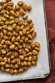 roasted pistachios on a baking sheet ready to be cooked in the oven