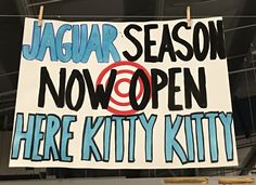 a sign hanging from the ceiling that says, jaguar season now open here kitty kitty