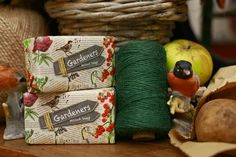 two green twine spools sitting next to each other on a wooden table