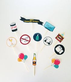 there are many cupcake toppers on the stick with some drinks and balloons around them