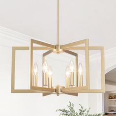 a chandelier hanging from the ceiling in a room with white walls and wood flooring