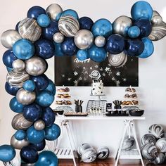 an arch made out of blue and silver balloons