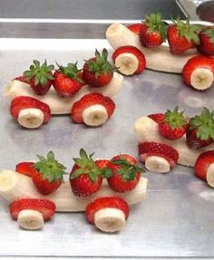 strawberries and bananas are arranged in the shape of a train on a baking sheet