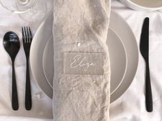 a place setting with napkins, silverware and black utensils