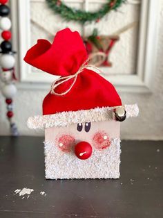 a christmas decoration made out of toilet paper with a santa hat on it's head