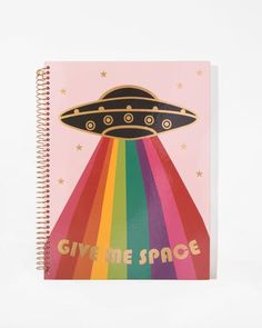 a spiral notebook with the words, give me space on it and an image of a rainbow