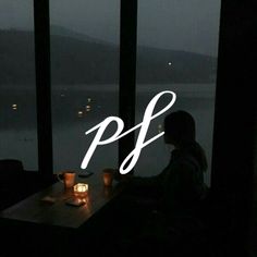 a person sitting at a table in front of a window with the words p f on it