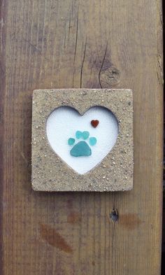 a dog's paw print in the shape of a heart on a wooden door