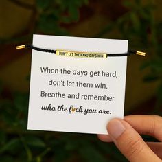 someone holding up a card that says, don't let the hard days win