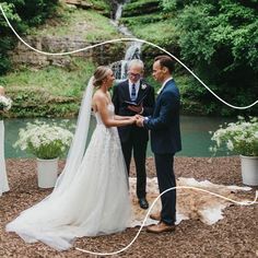 a bride and groom exchanging vows in front of a waterfall