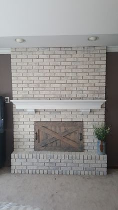 a living room with a white brick fireplace