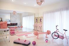 a room filled with lots of pink furniture and decor on top of white tile flooring