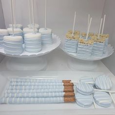 there are many desserts on the table with blue and white frosted cake pops