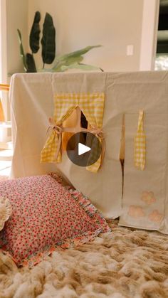 a teddy bear sitting on top of a bed next to a white table cloth covered tent