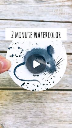 a hand holding a paper mouse with the words 2 minute watercolor on it