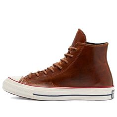 If you're looking for a classic sneaker with a premium twist, look no further than the Converse Chuck 70 High Color Leather 'Clove Brown'. This high-top sneaker features a full-grain leather upper with tonal stitching and waxed laces for a sophisticated look. The debossed All Star patch on the medial ankle adds a touch of retro style, while the glossy off-white rubber midsole provides cushioned comfort. Underfoot, the standard diamond-pattern rubber outsole delivers grippy traction. (SNKR/Unisex) Colored Converse, Lightweight Hiking Boots, Leather Converse, Converse Chuck 70, Leather High Tops, Chuck 70, Classic Sneakers, Mens Leather, Converse Chuck