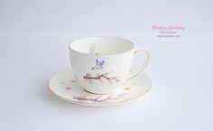 a cup and saucer sitting on top of a white table