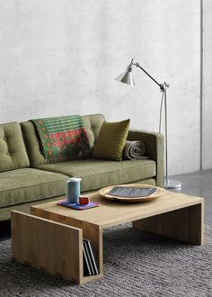 a coffee table sitting on top of a carpeted floor next to a green couch