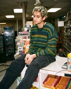 a man sitting on top of a counter in a store