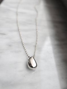 "Introducing our Silver Water Drop Necklace, a stunning piece that combines elegance with a touch of nature-inspired charm. Handcrafted with love and attention to detail, this necklace is a perfect accessory to adorn your neckline and add a delicate shimmer to any outfit. Crafted from high quality materials, this necklace features a dainty teardrop pendant, carefully shaped to resemble a beautiful water droplet. The pendant is Sterling Silver plated over copper. The minimalistic design of this necklace allows the beauty of the pendant to take center stage. It hangs gracefully from a delicate sterling silver chain, offering an adjustable length that ensures the perfect fit for every neckline. Whether you wear it as a standalone piece or layer it with your favorite necklaces, this versatile Elegant Silver Water Drop Earrings, Elegant Silver Water Drop Jewelry, Silver Water Drop Earrings As Gift, Silver Drop Charm Necklaces With Clavicle Chain, Minimalist Water Drop Jewelry For Gifts, Minimalist Water Drop Jewelry As Gift, Minimalist Water Drop Jewelry Gift, Minimalist Polished Teardrop Pendant Necklace, Minimalist Teardrop Pendant Necklace With Polished Finish