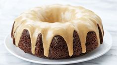 a bundt cake on a white plate with icing drizzled over it