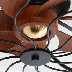 a close up of a ceiling fan with wood and metal blades on it's face