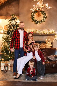 a family posing for a photo in front of a christmas tree