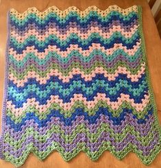 a crocheted blanket sitting on top of a wooden table