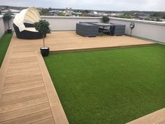 an outdoor deck with grass and furniture on it