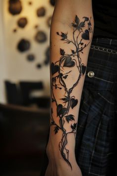 a woman's arm with a vine tattoo on the left side of her arm