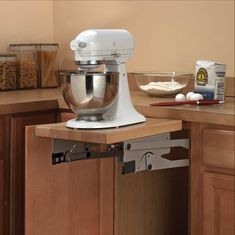 a white mixer sitting on top of a wooden counter