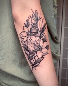 a woman's arm with a clock and flowers tattoo on the left side of her arm