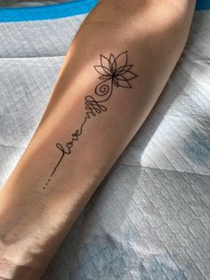 a woman's arm with a tattoo on it that reads, love and has a flower