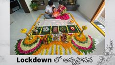 a man and woman sitting on top of a table covered in flowers