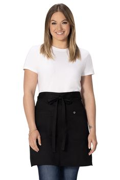 a woman in a white shirt and black skirt with her hands on her hips, smiling at the camera