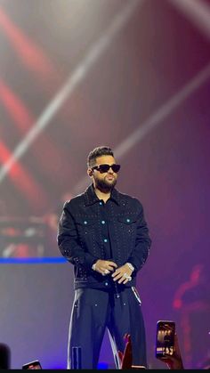 a man standing on top of a stage wearing sunglasses