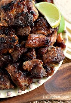 there are two pictures of some meat on the plate and one is grilled with limes