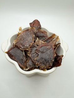 a white bowl filled with dried figs on top of a table