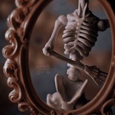 there is a skeleton in the mirror with its head turned to look like it's holding a bone