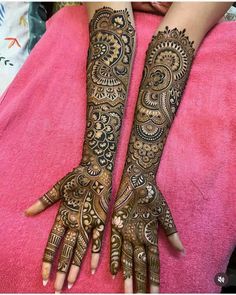 two hands with henna tattoos on them