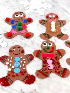 gingerbread cutouts are sitting on a table with white snowflakes around them