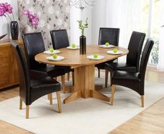 a dining room table with black chairs around it