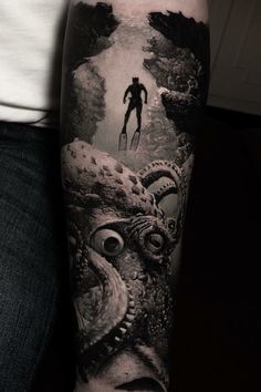 a man's arm with an octopus and diver in the water tattoo on it