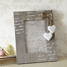 two hearts are attached to a wooden photo frame with twine ribbons on the edge