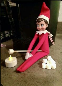 an elf is playing with marshmallows on the floor