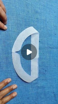 someone is cutting out a piece of paper that looks like the letter d with scissors